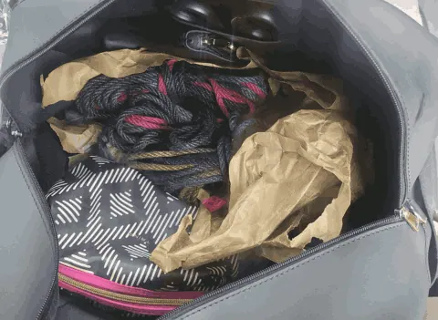 Rope bag interior showing coiled jute rope in black and bright pink.