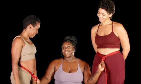 Three people demonstrate red rope bondage techniques.