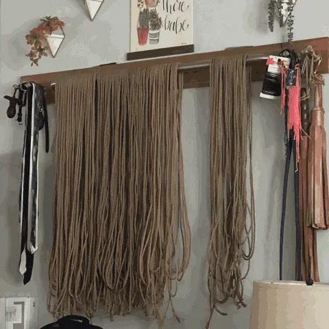 Rope collection hanging on a wooden rod showing various colors.